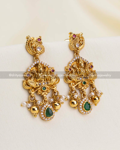 Earrings with Ram Parivar design, green teardrop stones, CZ highlights, and pearl drops.
