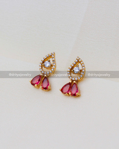 Pair of matching earrings featuring teardrop red stones surrounded by cubic zirconia.
