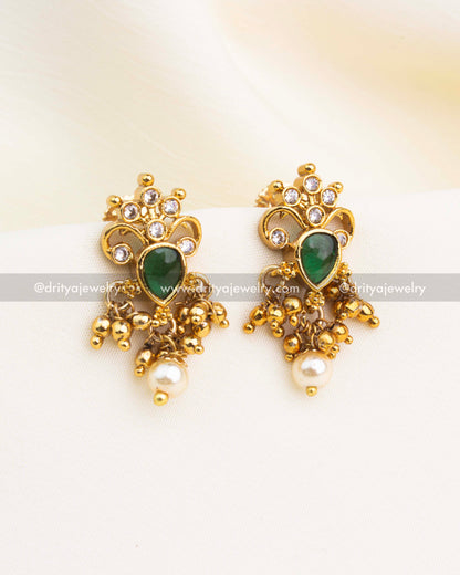 Emerald green stone earrings with pearl drops and gold-plated Nakshi detailing.