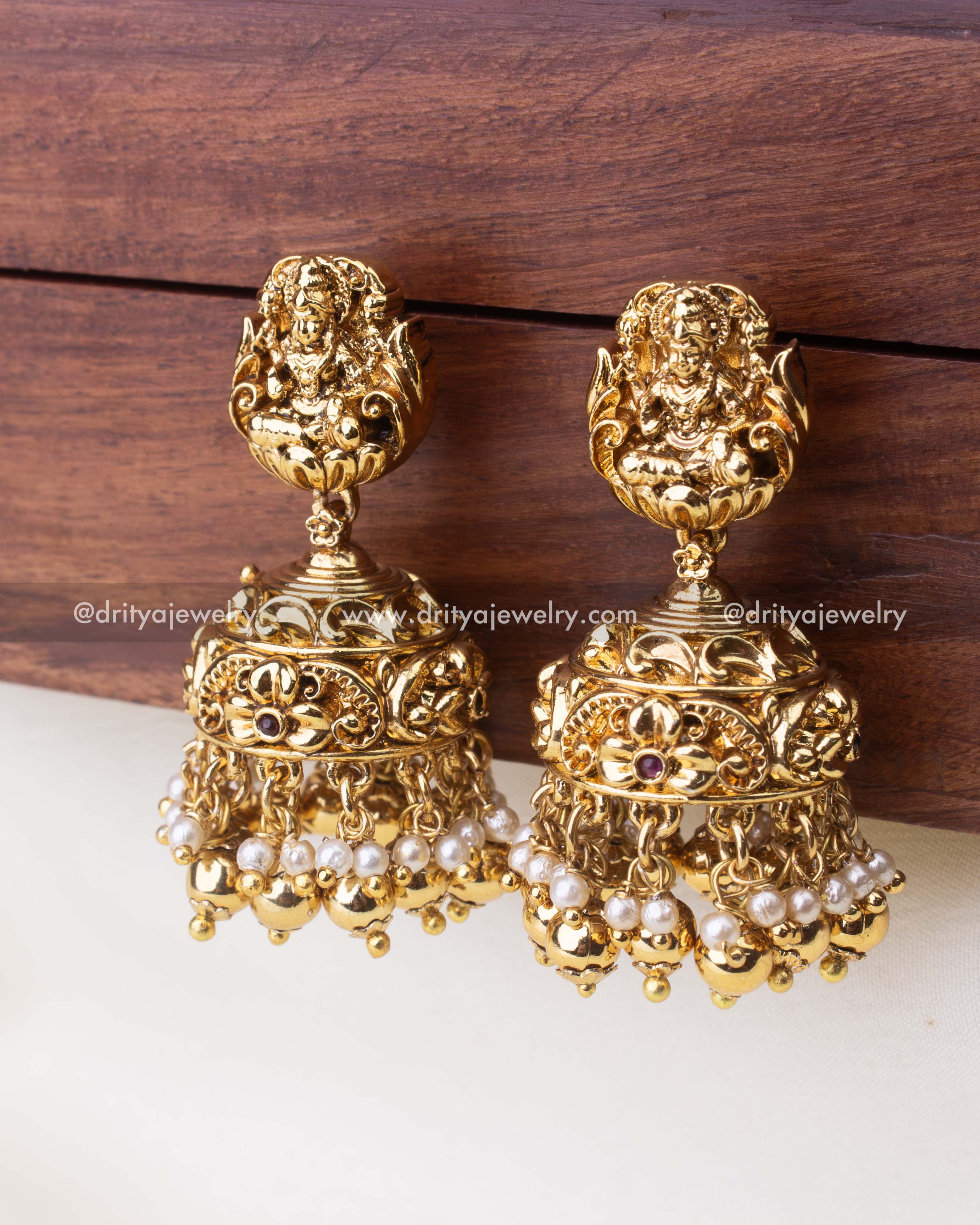 Traditional temple jewelry Jhumkas with Lakshmi motif, pearls, and golden bead drops.