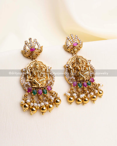 Temple-style earrings with Lakshmi Devi, antique gold polish, and ruby emerald detailing.