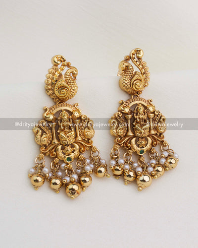 Temple-style Lakshmi earrings with peacock top, pearls, and gold ball drops.