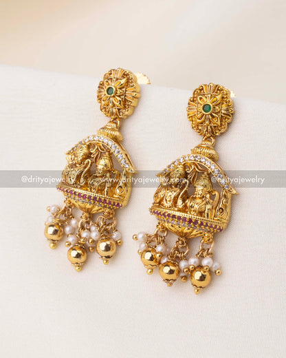Temple jewelry earrings with Ram Parivar motif, CZ highlights, and pearl-golden bead drops.
