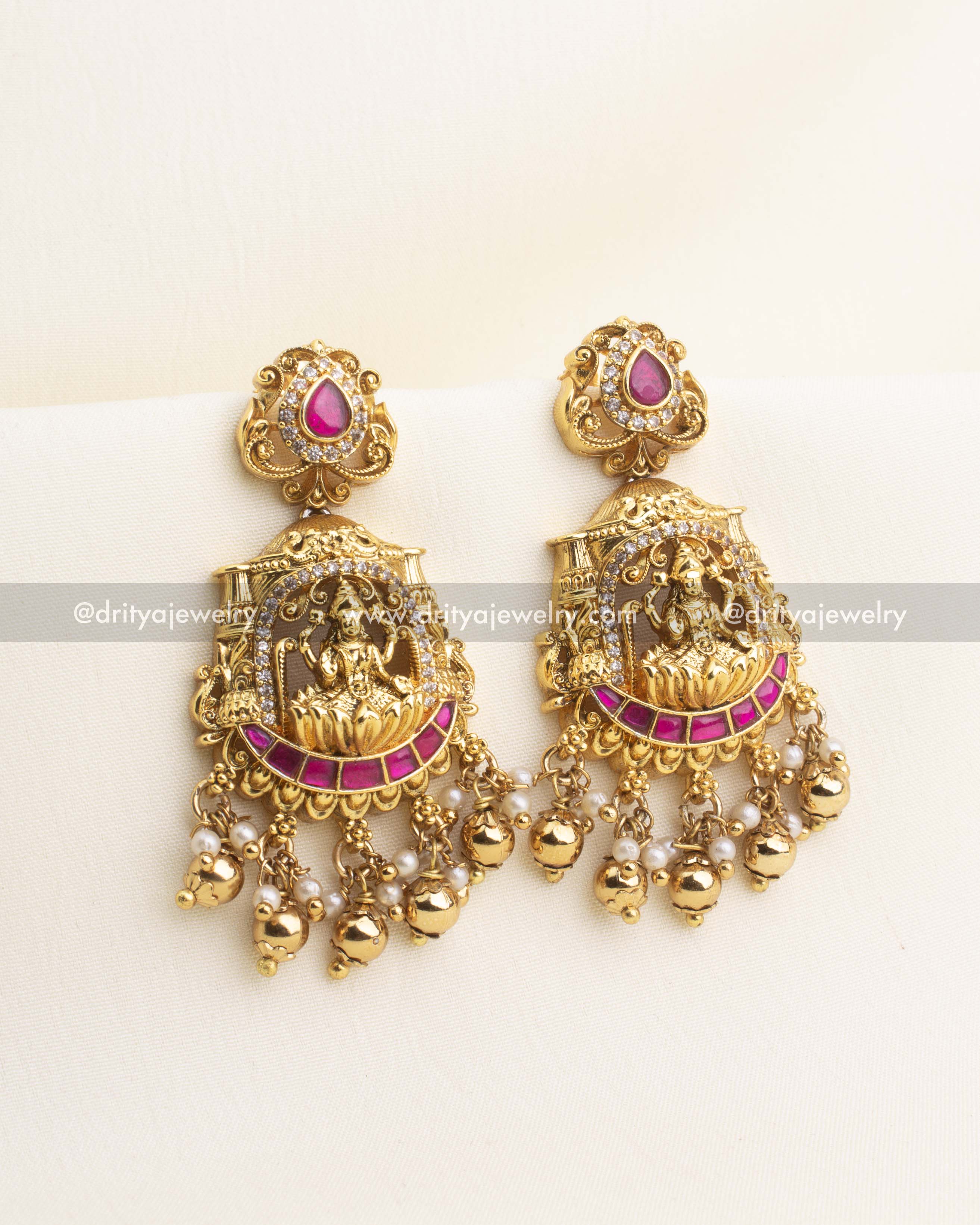 Kemp temple dangler earrings with Lakshmi motif, pearl clusters, and antique gold polish.