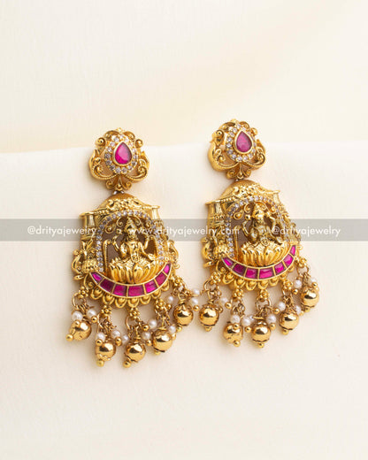 Kemp temple dangler earrings with Lakshmi motif, pearl clusters, and antique gold polish.