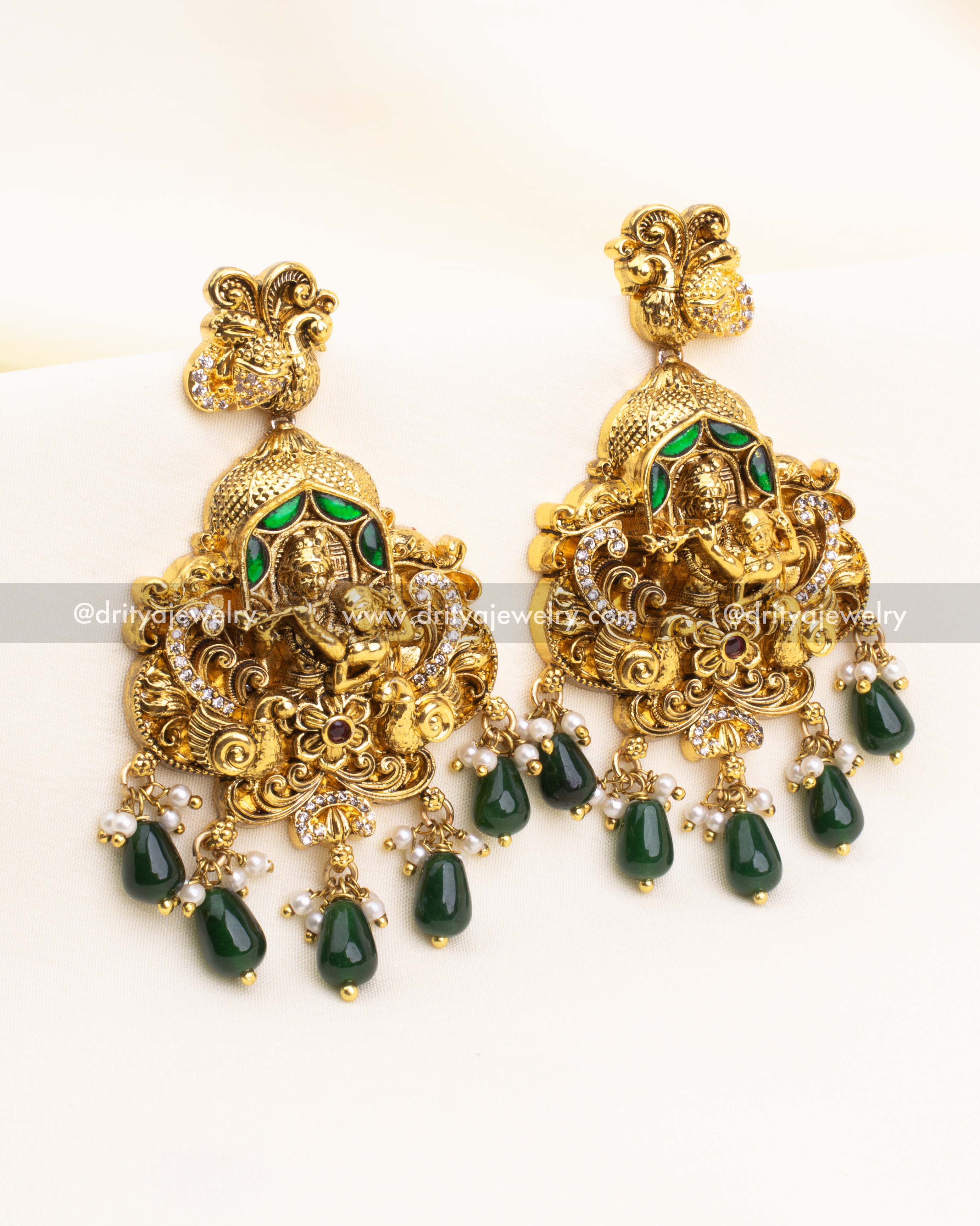 Lakshmi-styled jhumka earrings with emerald green drops and peacock motif top.