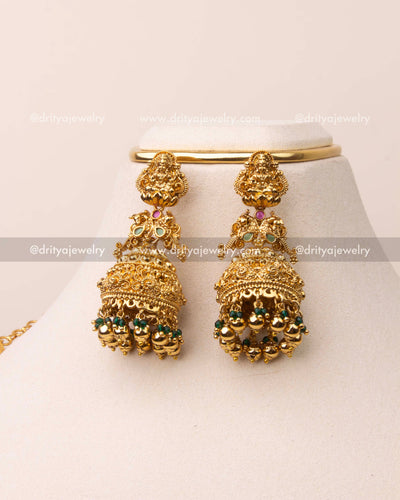 Matching temple jhumka earrings with gold polish and green beads