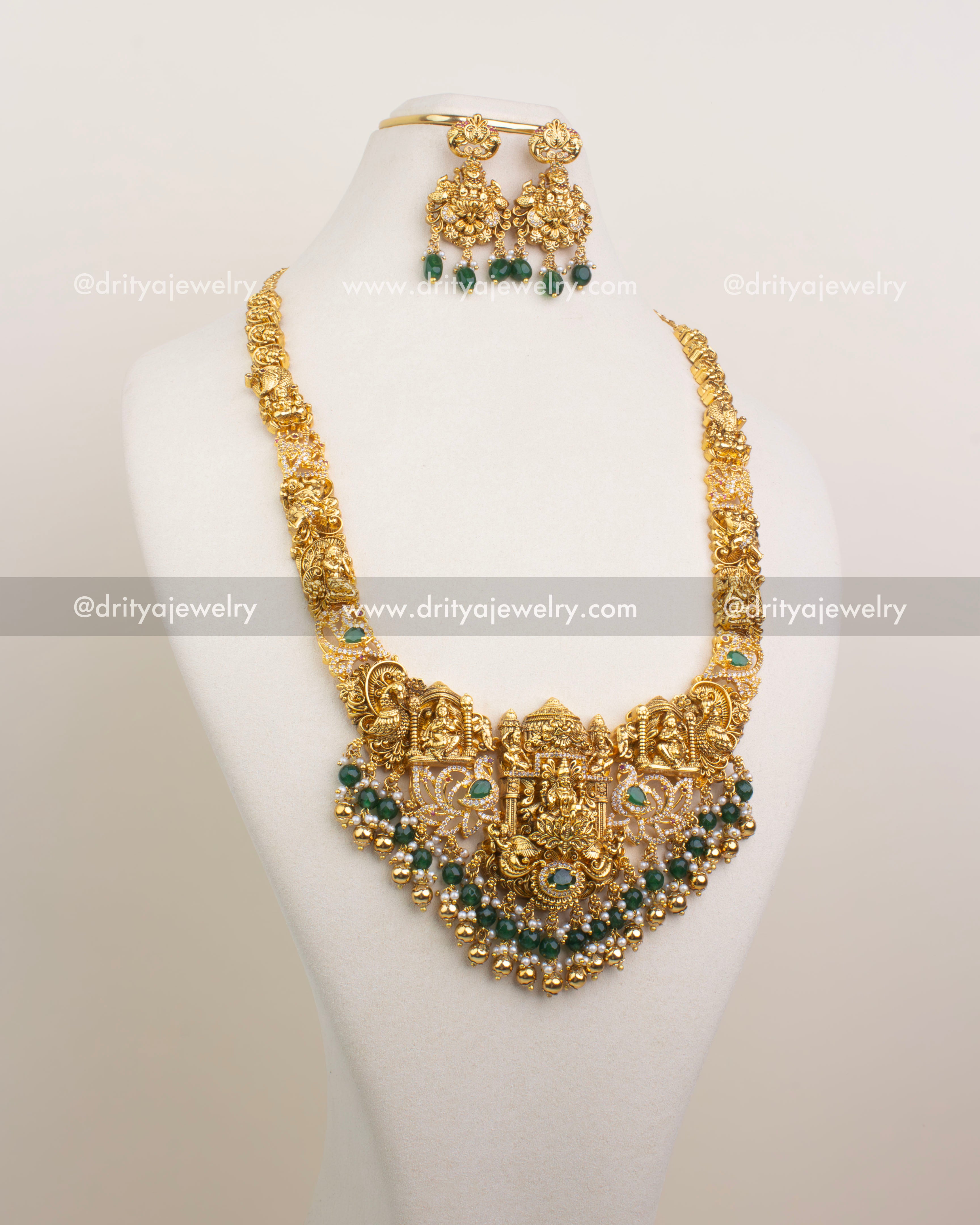 Front view of the Premium Nakshi Long Haram featuring Lakshmi Devi, peacocks, and green bead detailing, paired with matching jhumkas.