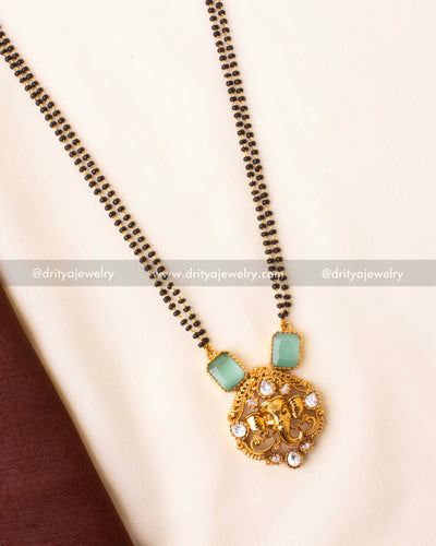 Gold-plated black beads mangalsutra with mint green stones and Ganesha motif pendant.