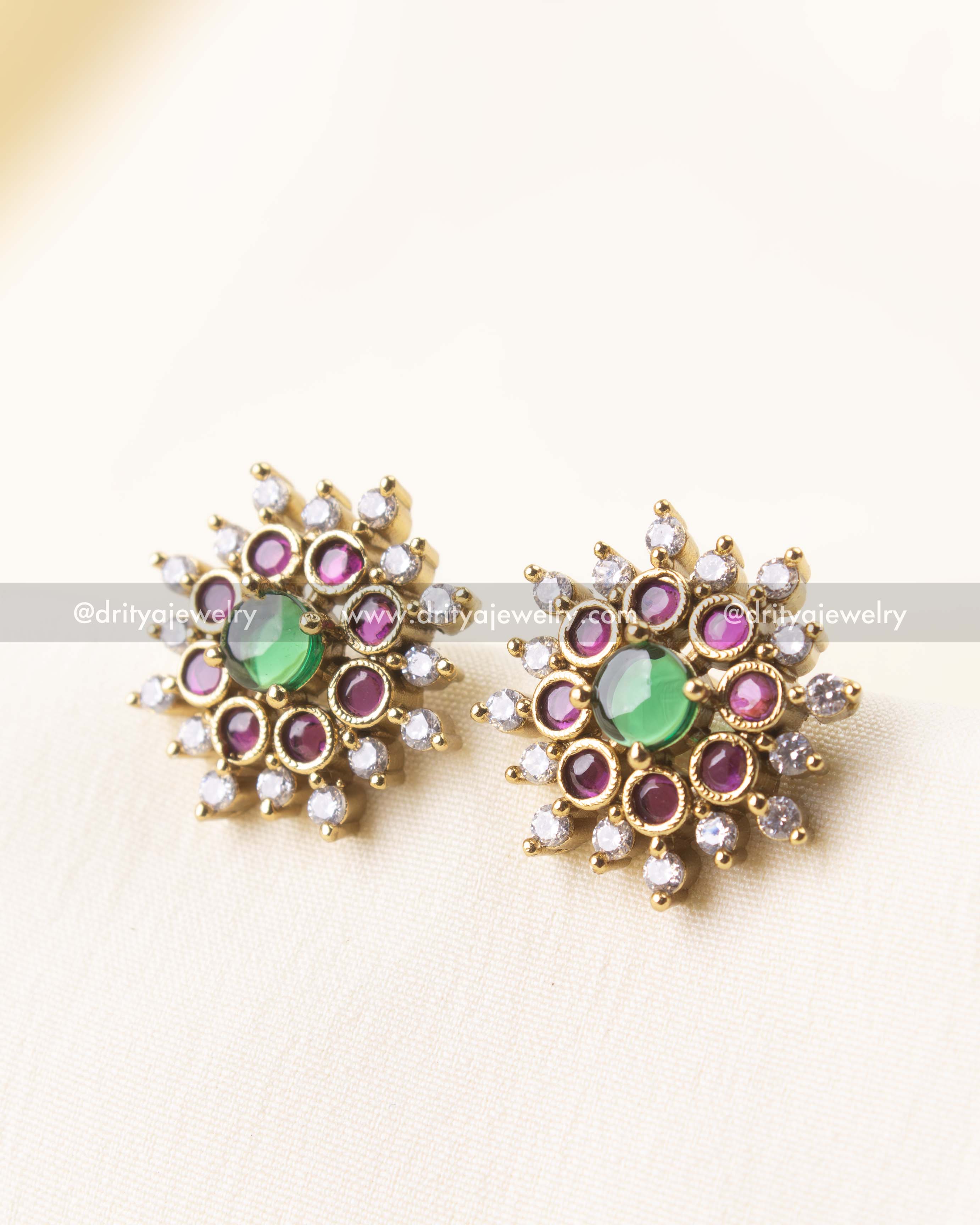 Elegant floral design CZ studs with green and red stones in a circular burst setting.