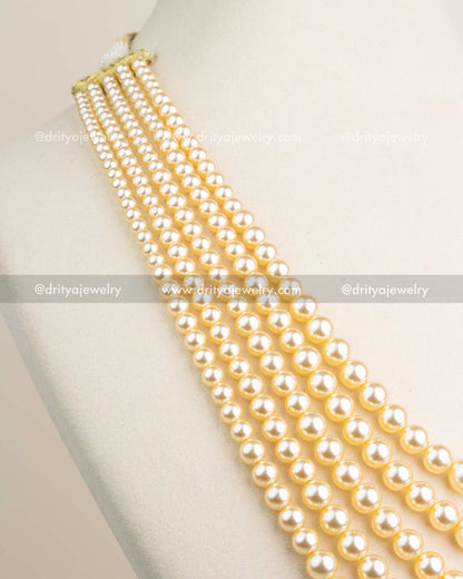Close-up of premium imitation pearls arranged in cascading layers with soft golden sheen.