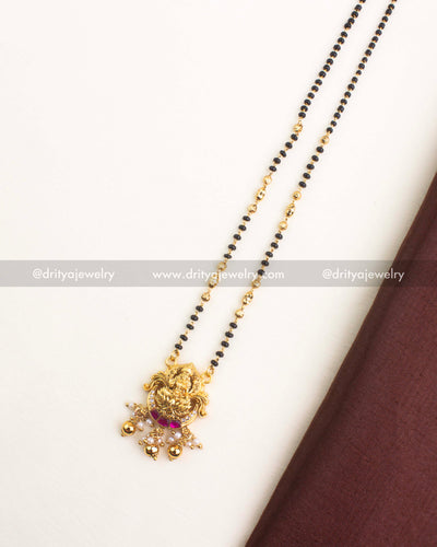 Nakshi-style pendant featuring Goddess Lakshmi with kemp butta stones, CZ accents, and pearl bead danglers.