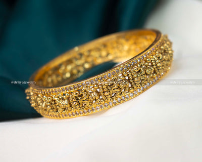 Exquisite Nakshi CZ Stone Bangle from Dritya Jewelry, featuring detailed carvings and sparkling CZ stones, perfect for weddings and cultural festivities.