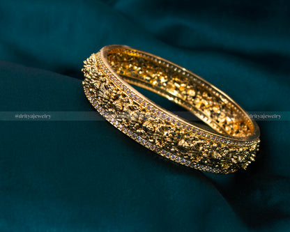 Exquisite Nakshi CZ Stone Bangle from Dritya Jewelry, featuring detailed carvings and sparkling CZ stones, perfect for weddings and cultural festivities.