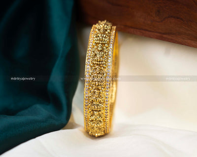 Exquisite Nakshi CZ Stone Bangle from Dritya Jewelry, featuring detailed carvings and sparkling CZ stones, perfect for weddings and cultural festivities.