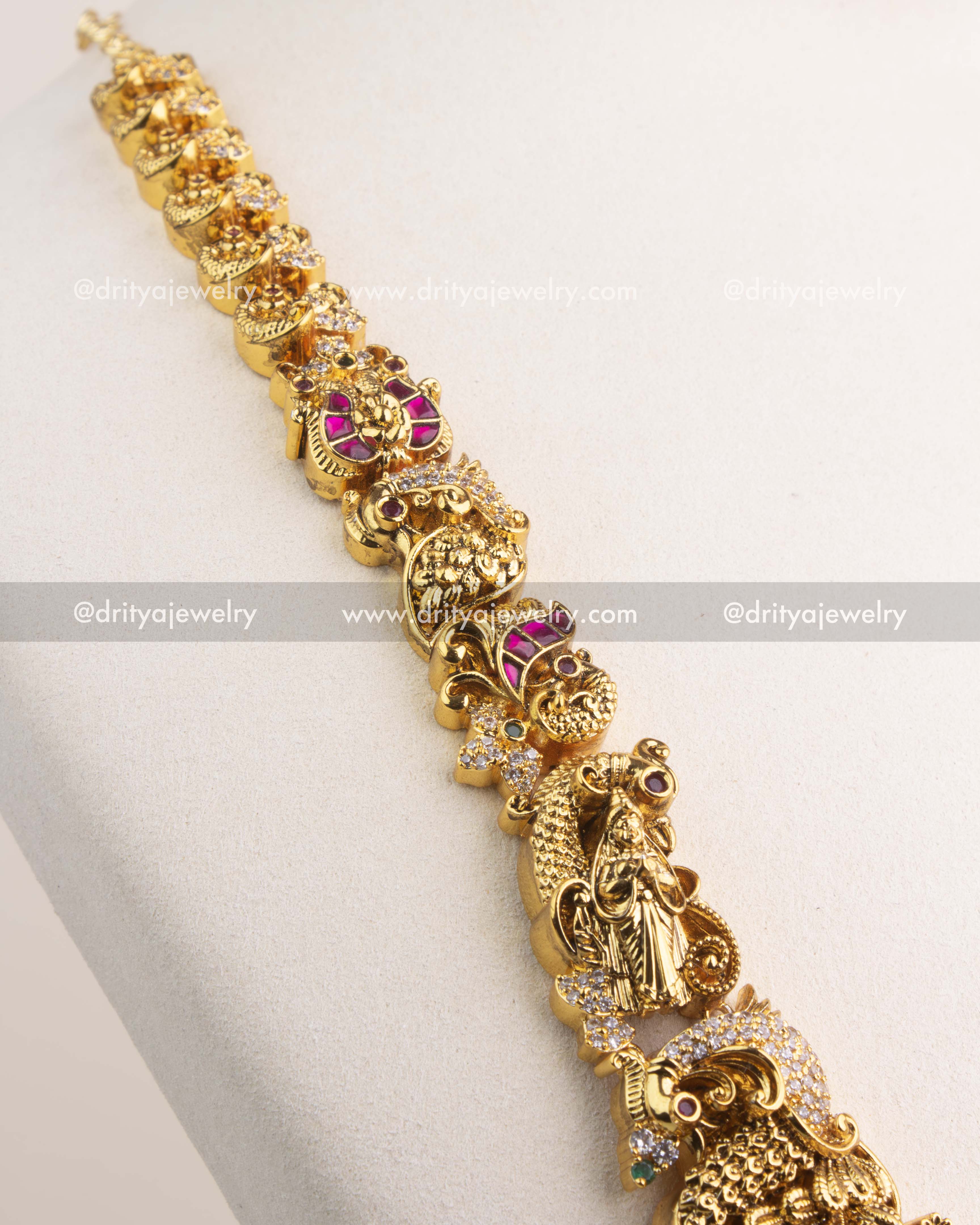 Detailed view of long necklace chain with temple motifs, peacocks, and floral carvings.