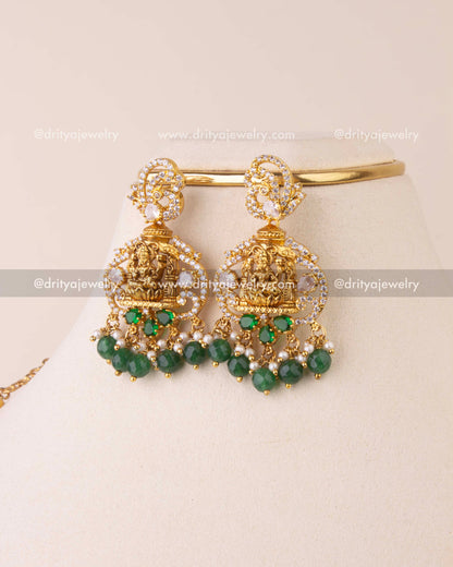 Pair of temple-style earrings with Goddess Lakshmi detailing, CZ stones, and green beads.