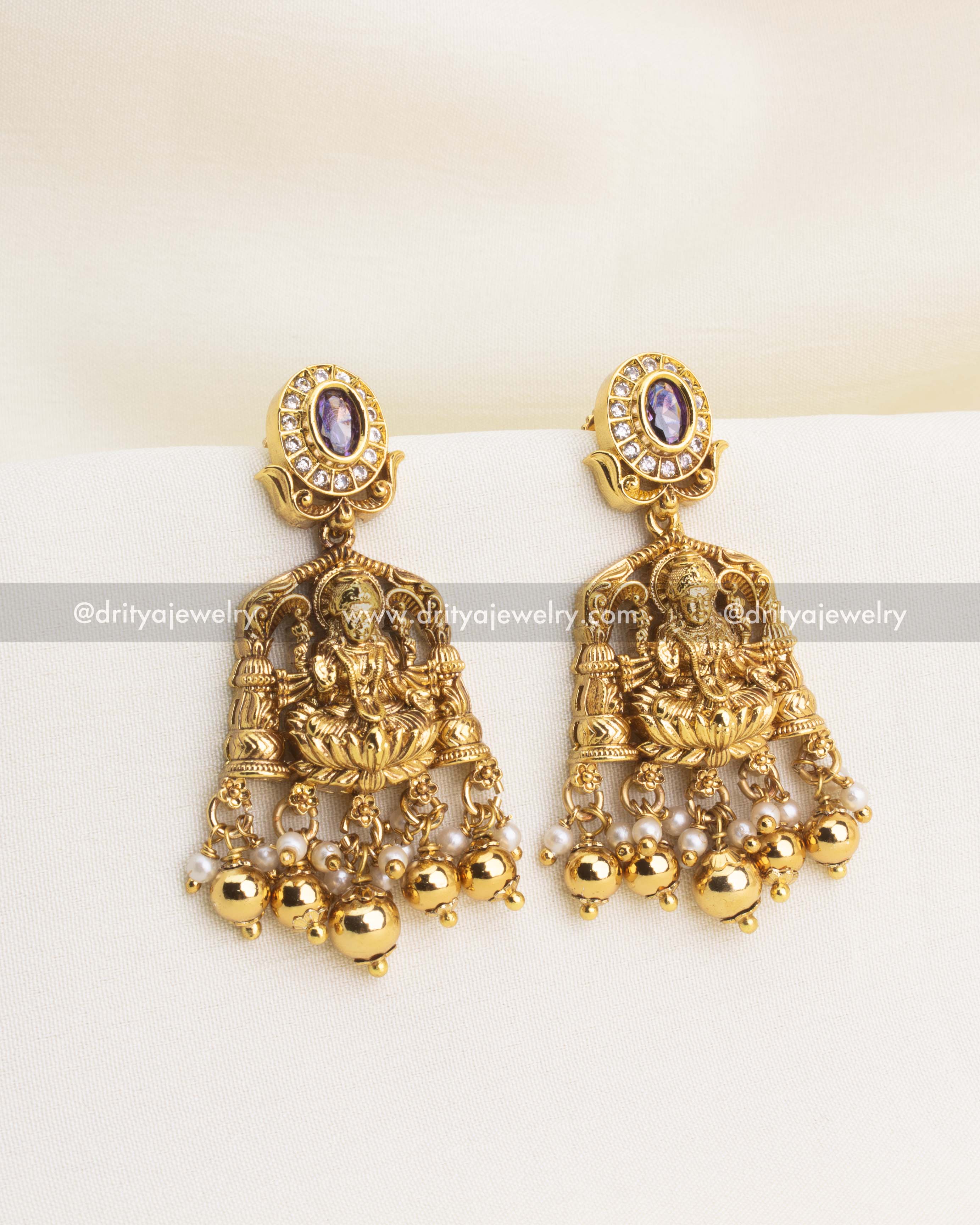 Temple-style earrings with Lakshmi carving, CZ sparkle, and purple bead drops.