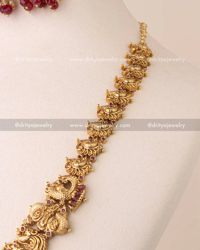 Traditional Nakshi chain with detailed motifs and ruby bead finish.