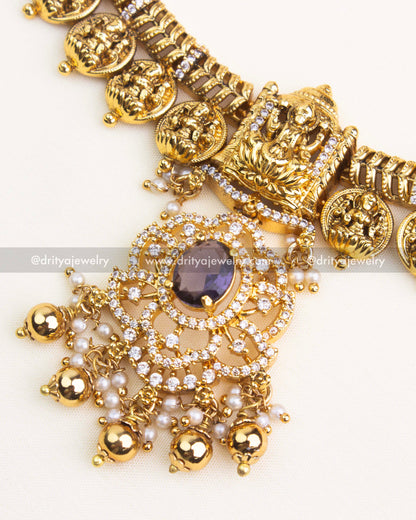 Close-up of temple-style pendant with purple center stone, CZ detailing, and pearl drops.