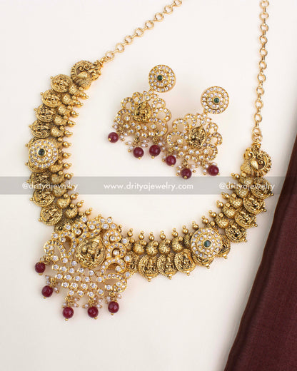 Temple-inspired Nakshi Kasulu necklace with Lakshmi motifs, antique gold plating, and ruby red bead drops.