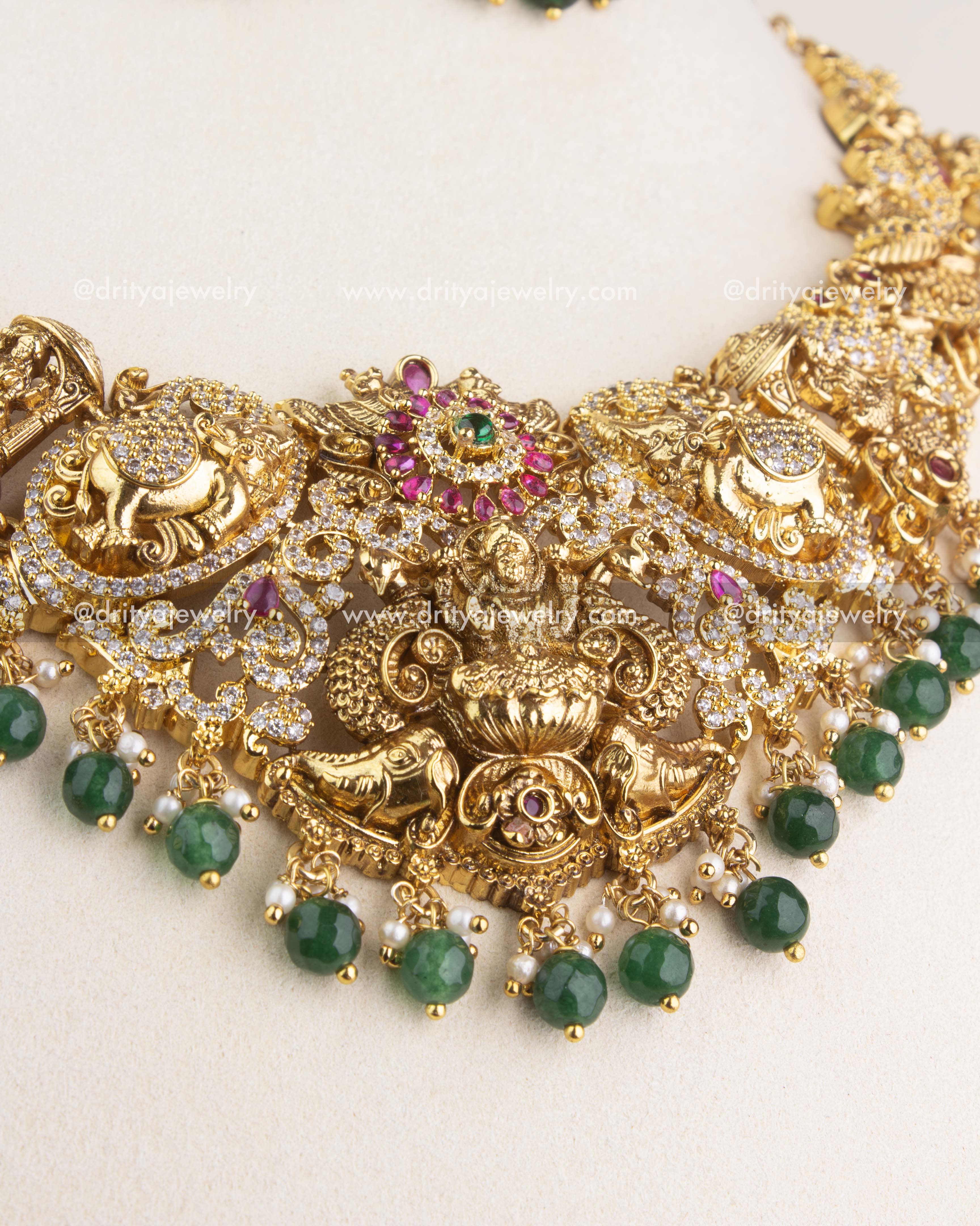 Close-up of Nakshi short necklace featuring Lakshmi motif with ruby accents and green bead drops.