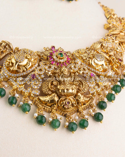 Close-up of Nakshi short necklace featuring Lakshmi motif with ruby accents and green bead drops.