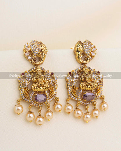 Premium gold nakshi temple dangler earrings with Lakshmi motif, purple stone, and pearl drops.
