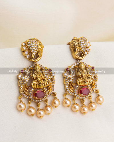 Premium Nakshi temple danglers with Goddess Lakshmi, red oval stone, CZ accents, and pearl drops.