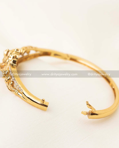Side view of openable free size temple kada with CZ stone detailing and antique gold polish
