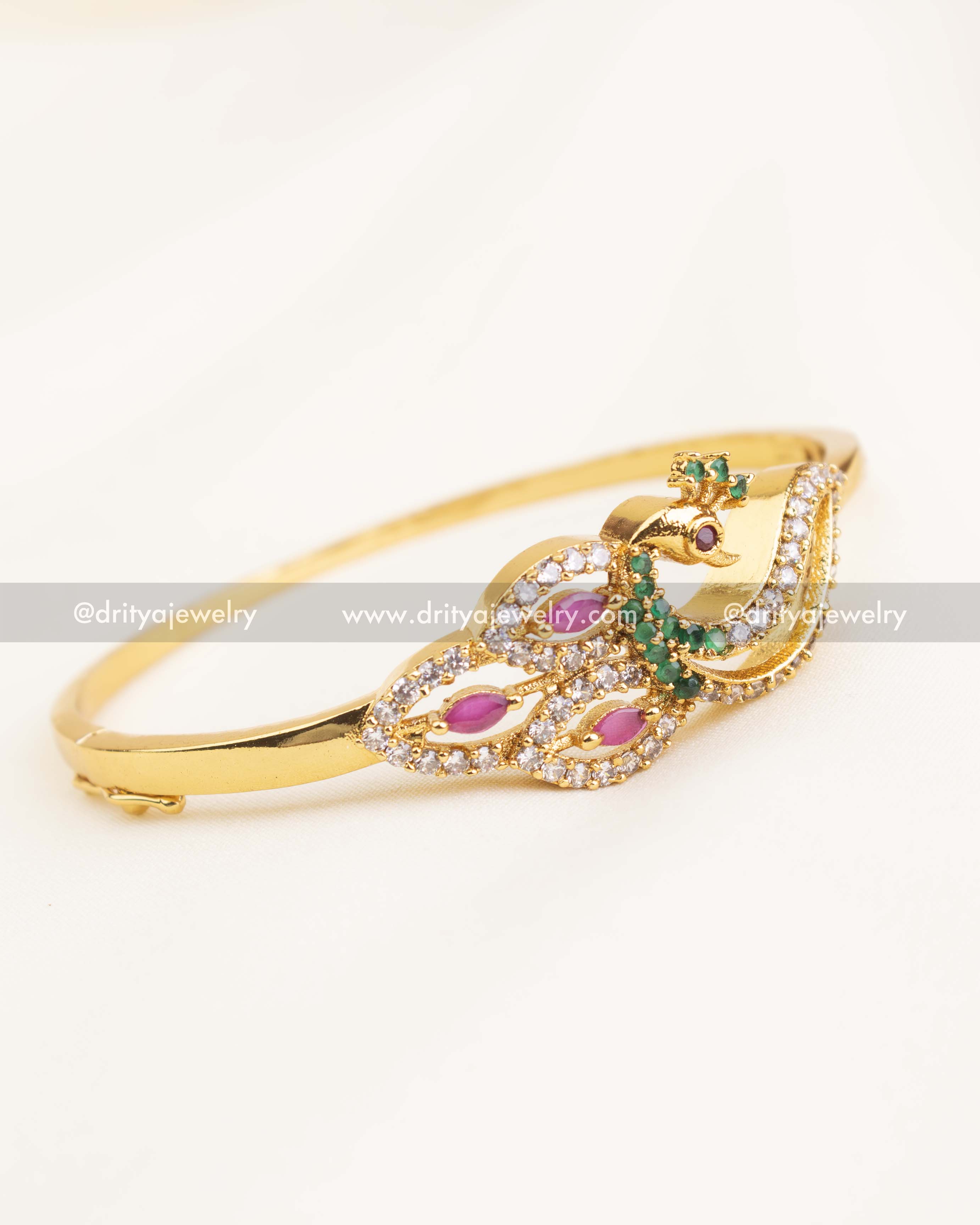 Gold-plated peacock design kada with pink and green stones in an openable free-size style