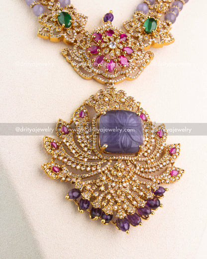 Detailed view of carved lavender centerpiece with CZ stones and ruby pink accents in gold setting.