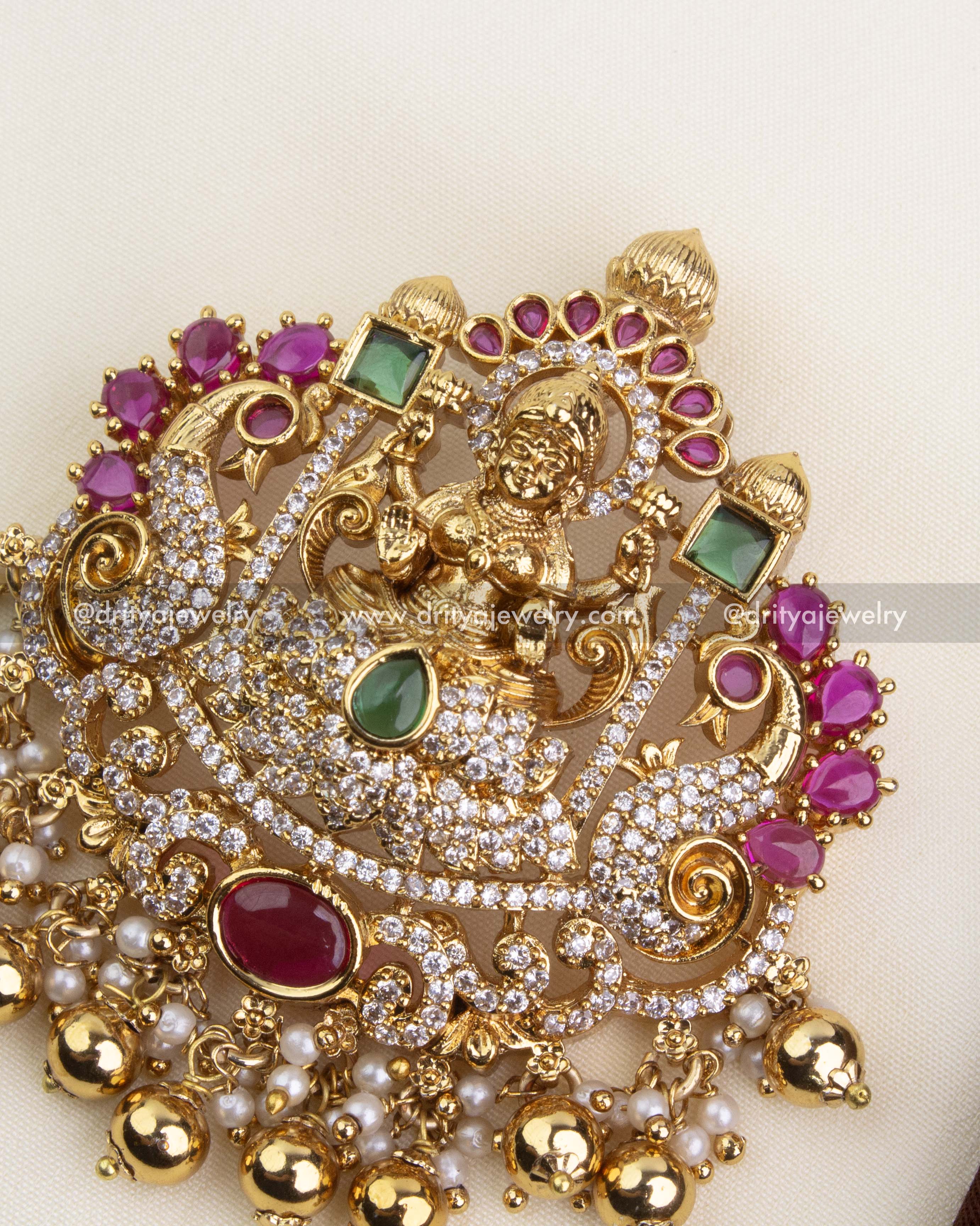 Zoomed-in view of ruby cabochons, CZ stones, and deity motif on temple pendant