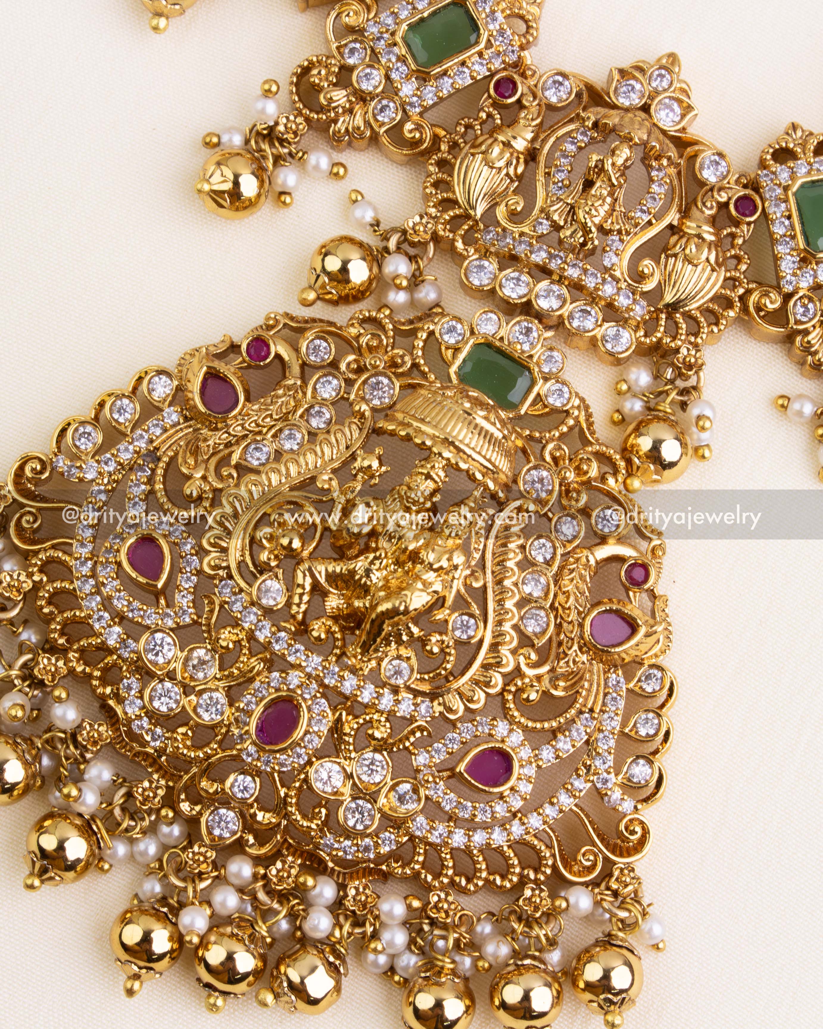 Statement pendant with Lord Narasimha in arch frame, embellished with CZs, ruby accents, and gold ball hangings.