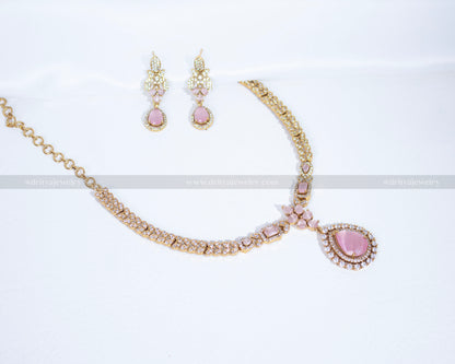 Dritya Jewelry’s gold-plated necklace set adorned with pink stones and Cubic Zirconia, featuring a teardrop pendant and intricate design.