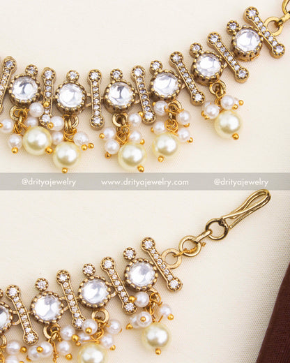 Close-up of Polki stones, Victorian CZ bars, and layered pearl clusters on Champaswaralu ear chains.