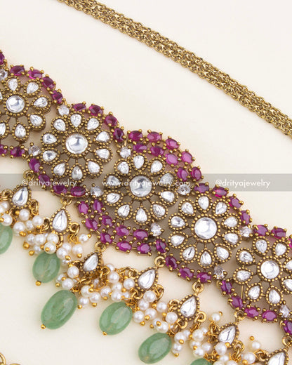 Detailed close-up of Polki floral motifs with ruby kundan outlines, pearls, and green droplet embellishments.