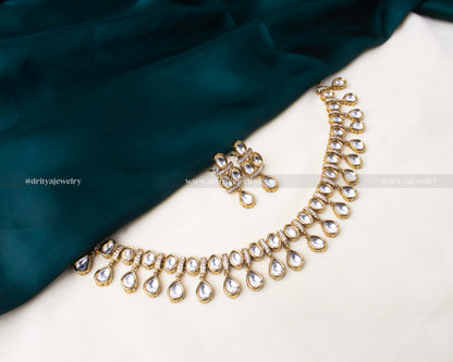 Traditional polki kundan short necklace with teardrop-shaped stones and gold-toned finish, paired with matching earrings.