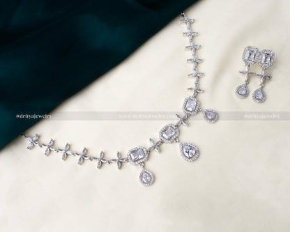 Elegant American Diamond necklace set with square and teardrop CZ stones in a silver-tone finish, paired with matching earrings.