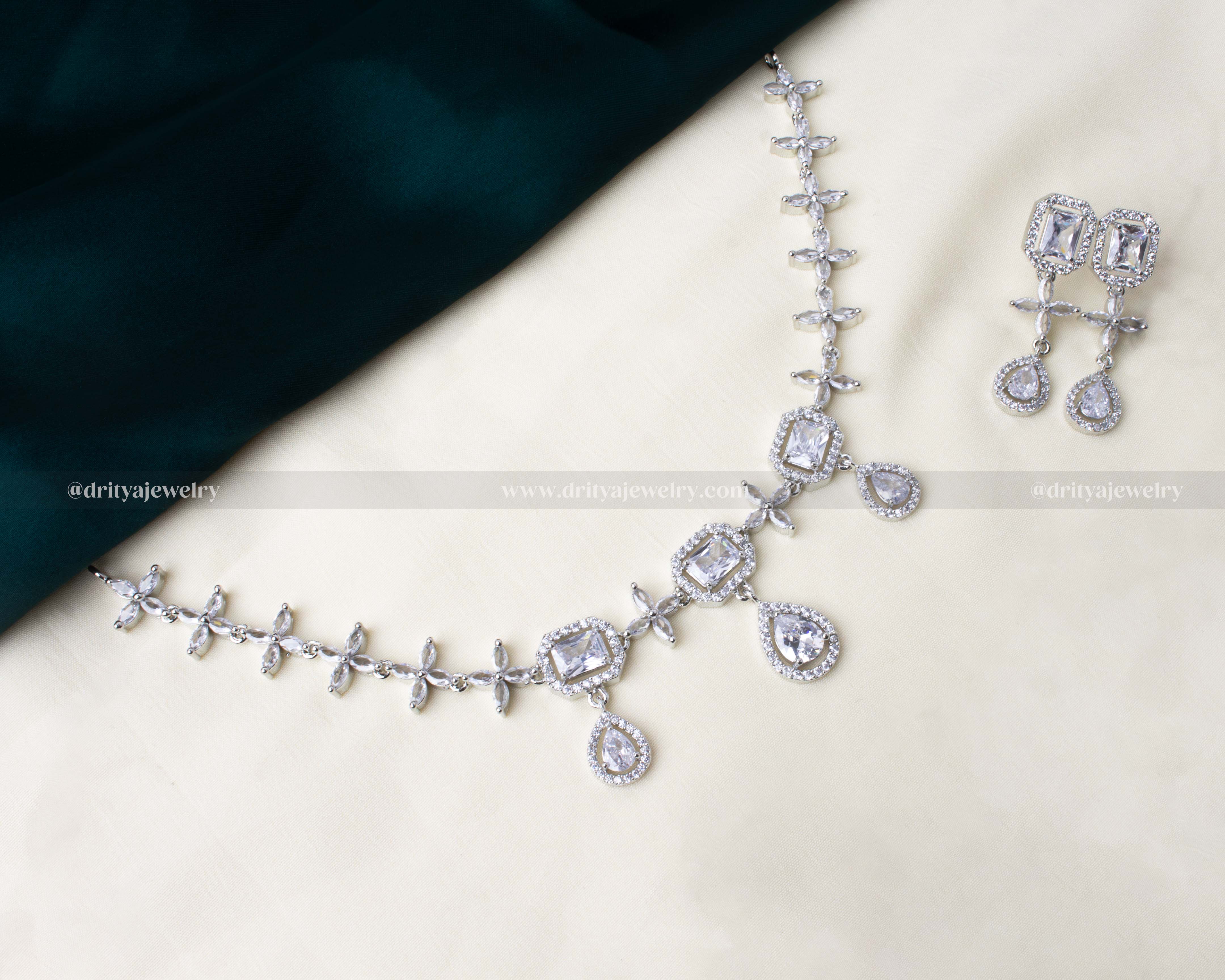 Elegant American Diamond necklace set with square and teardrop CZ stones in a silver-tone finish, paired with matching earrings.