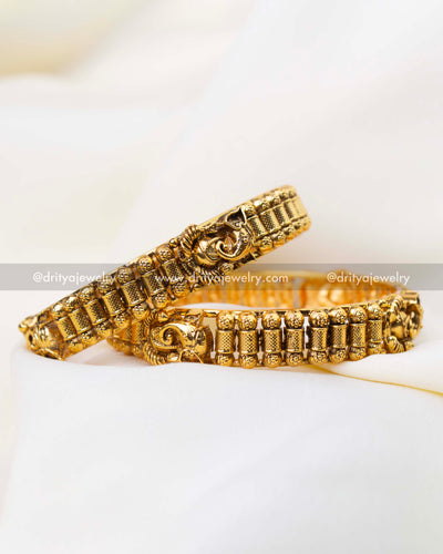 Traditional antique gold bangle pair with Lord Ganesha motif and temple detailing