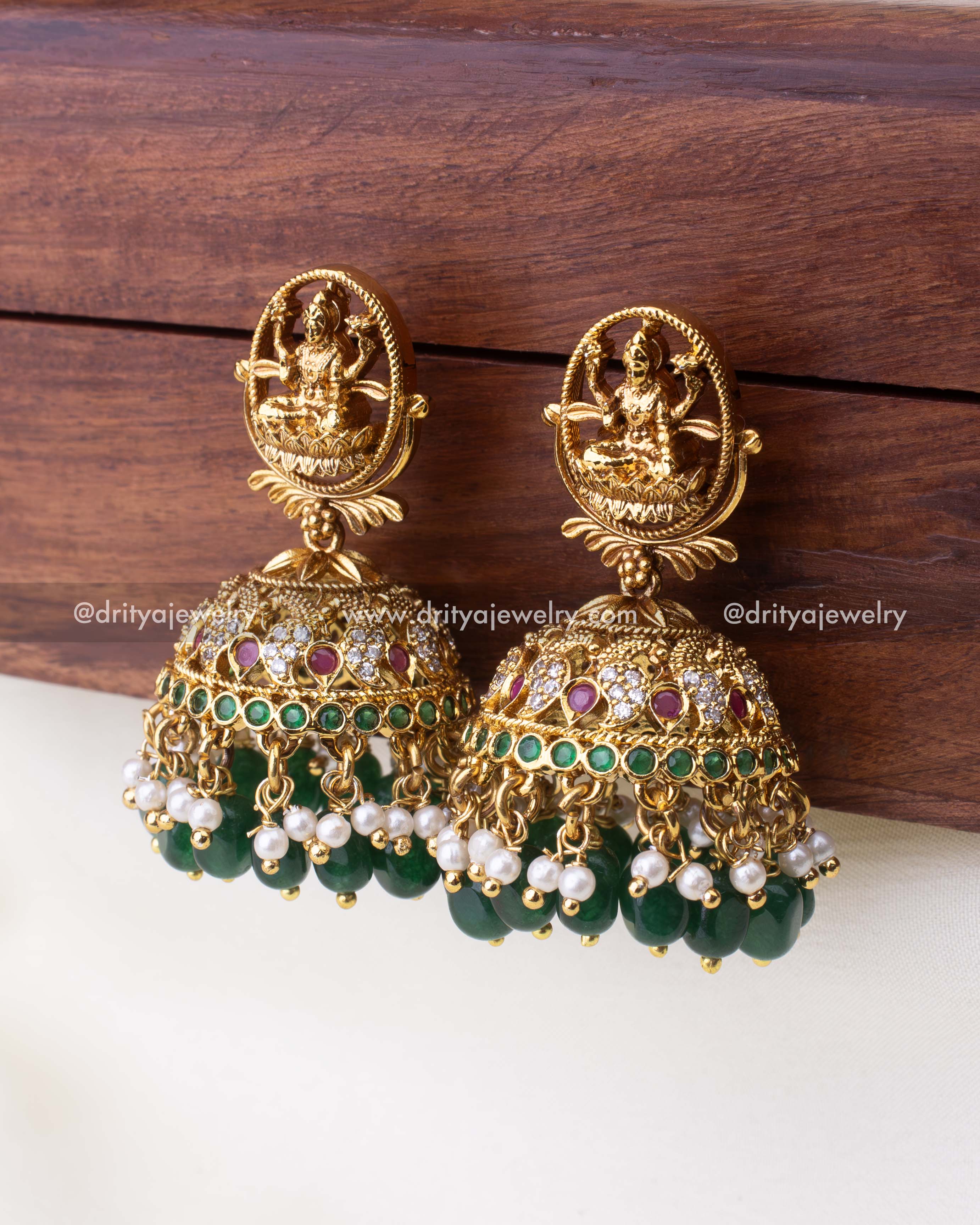 Detailed view of Jhumka dome with ruby and emerald accents, pearl clusters, and green bead drops.