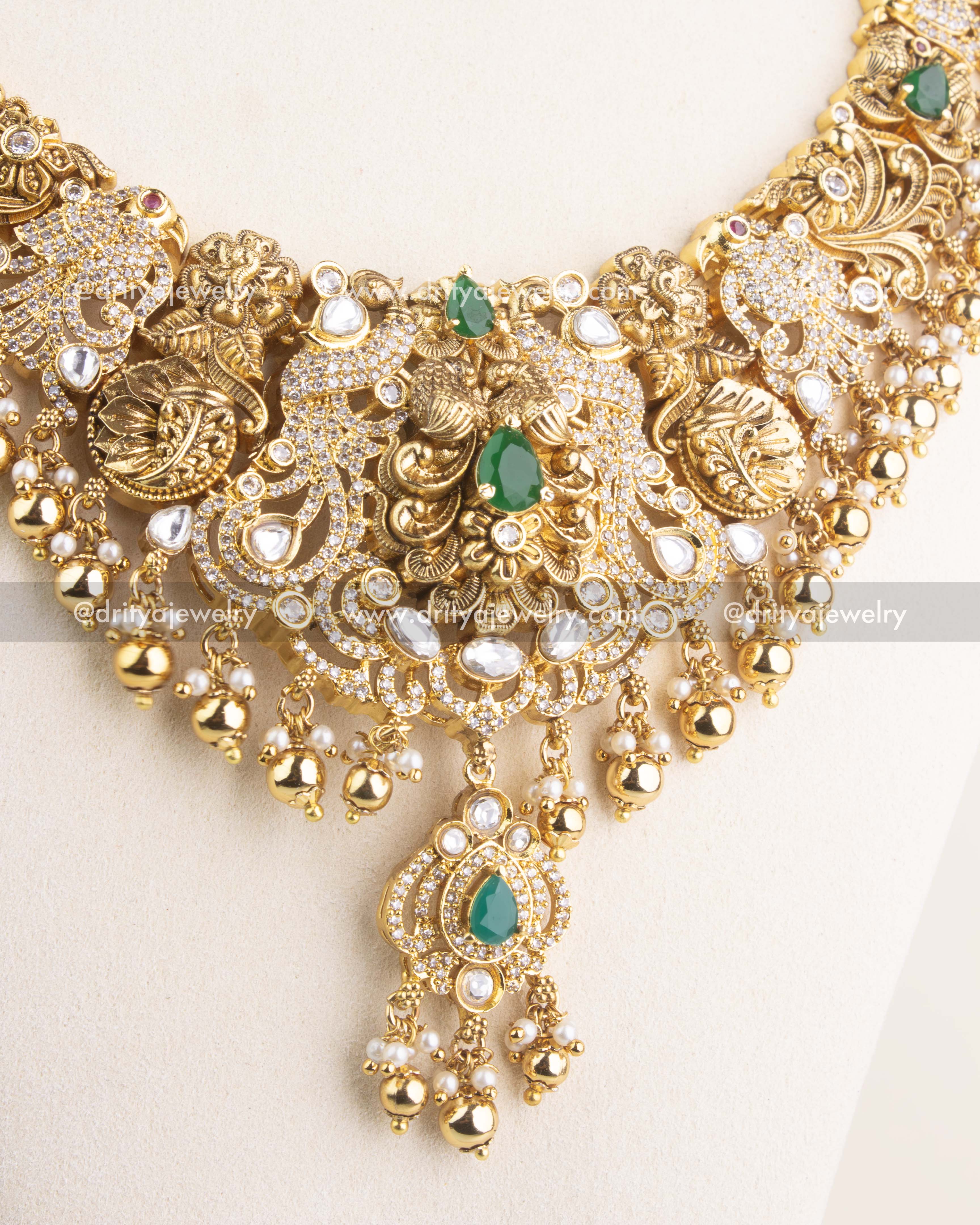 Close-up of the premium antique long necklace centerpiece featuring kundan detailing, green gemstones, and dangling gold beads.