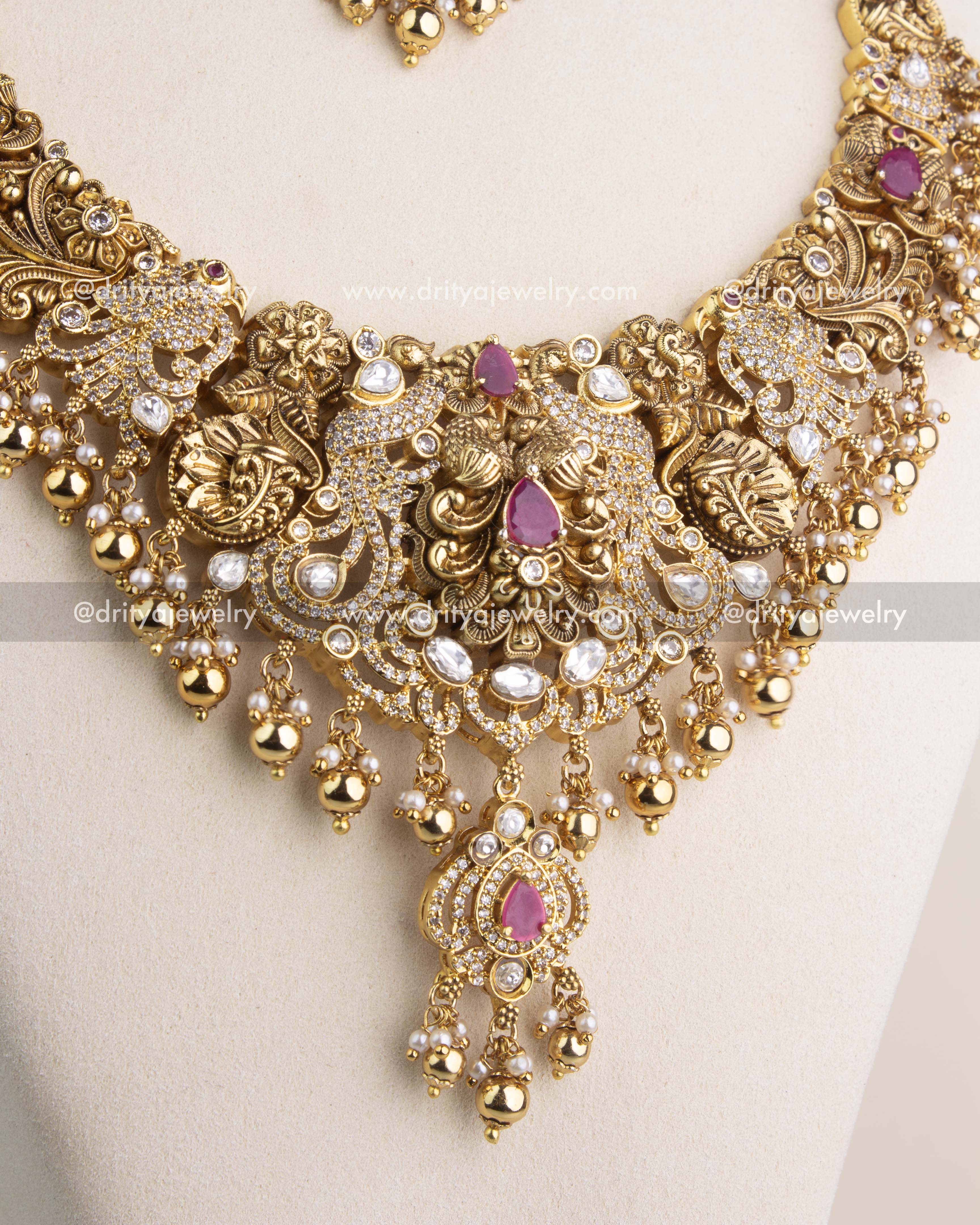 Close-up view of the antique long necklace centerpiece designed with kundan work, ruby stones, and bead drops.