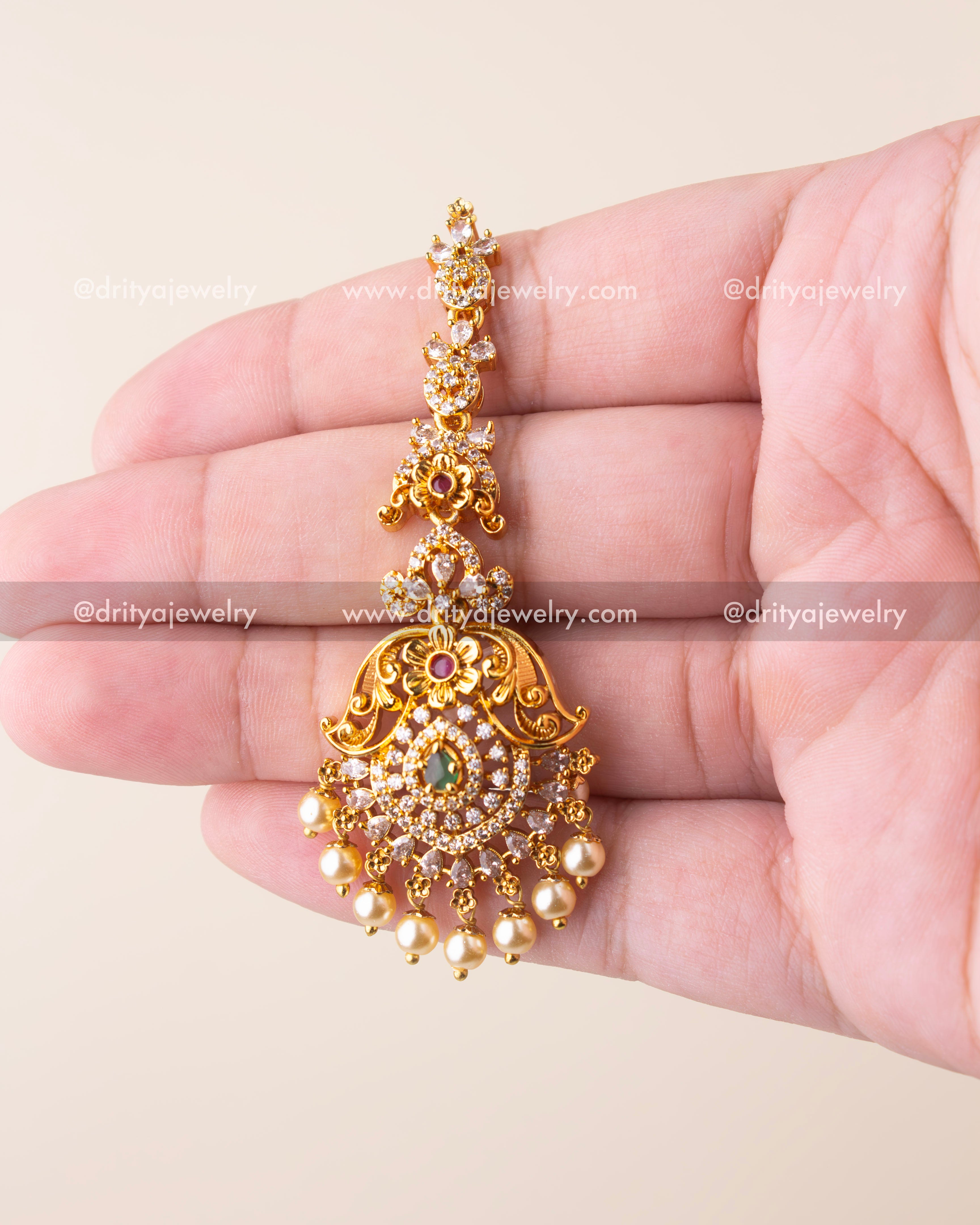 Elegant antique maang tikka with green stone centerpiece, CZ detailing, and pearl drops – no idol design.
