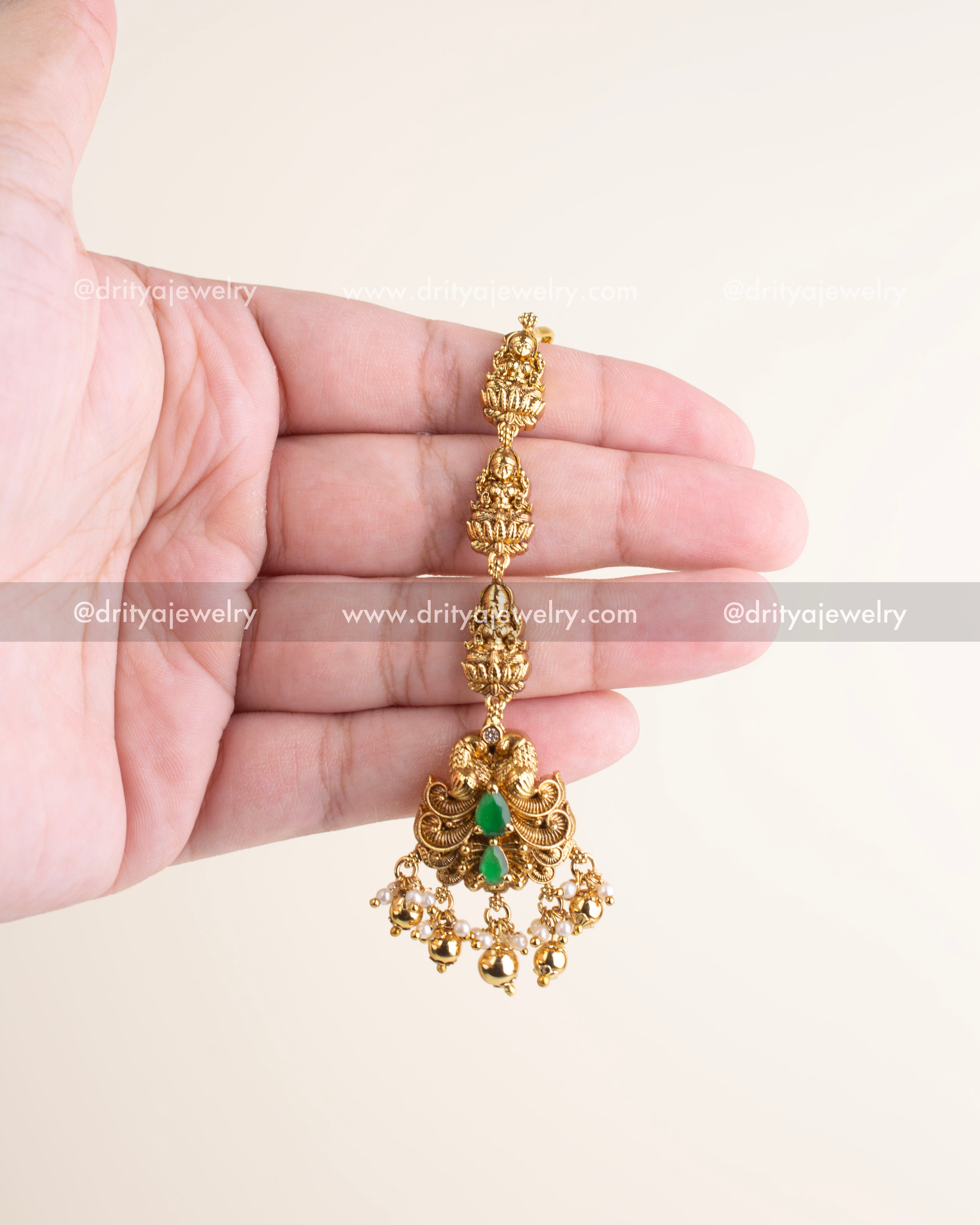 Traditional antique maang tikka with emerald green stones, nakshi work, and pearl danglers, perfect for bridal and festive looks.