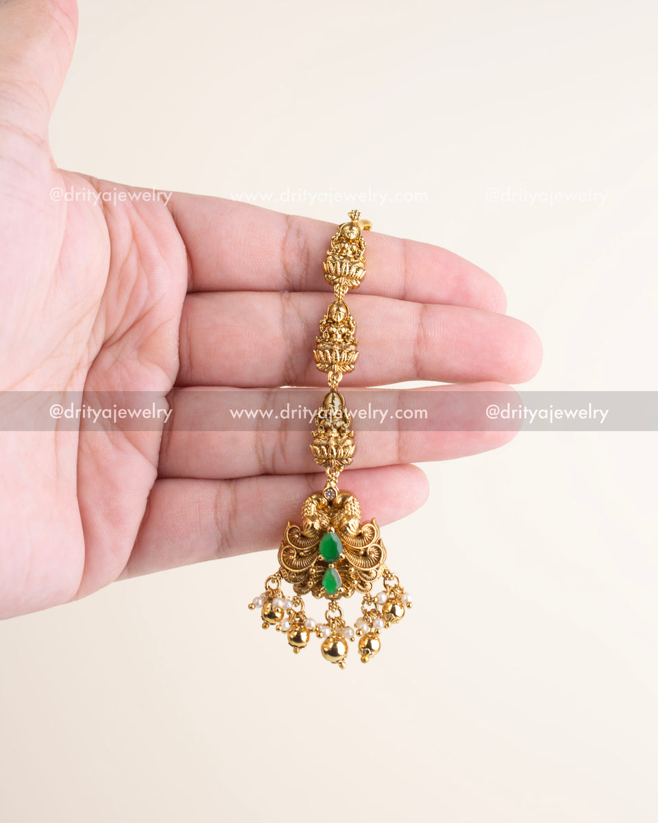 Traditional antique maang tikka with emerald green stones, nakshi work, and pearl danglers, perfect for bridal and festive looks.