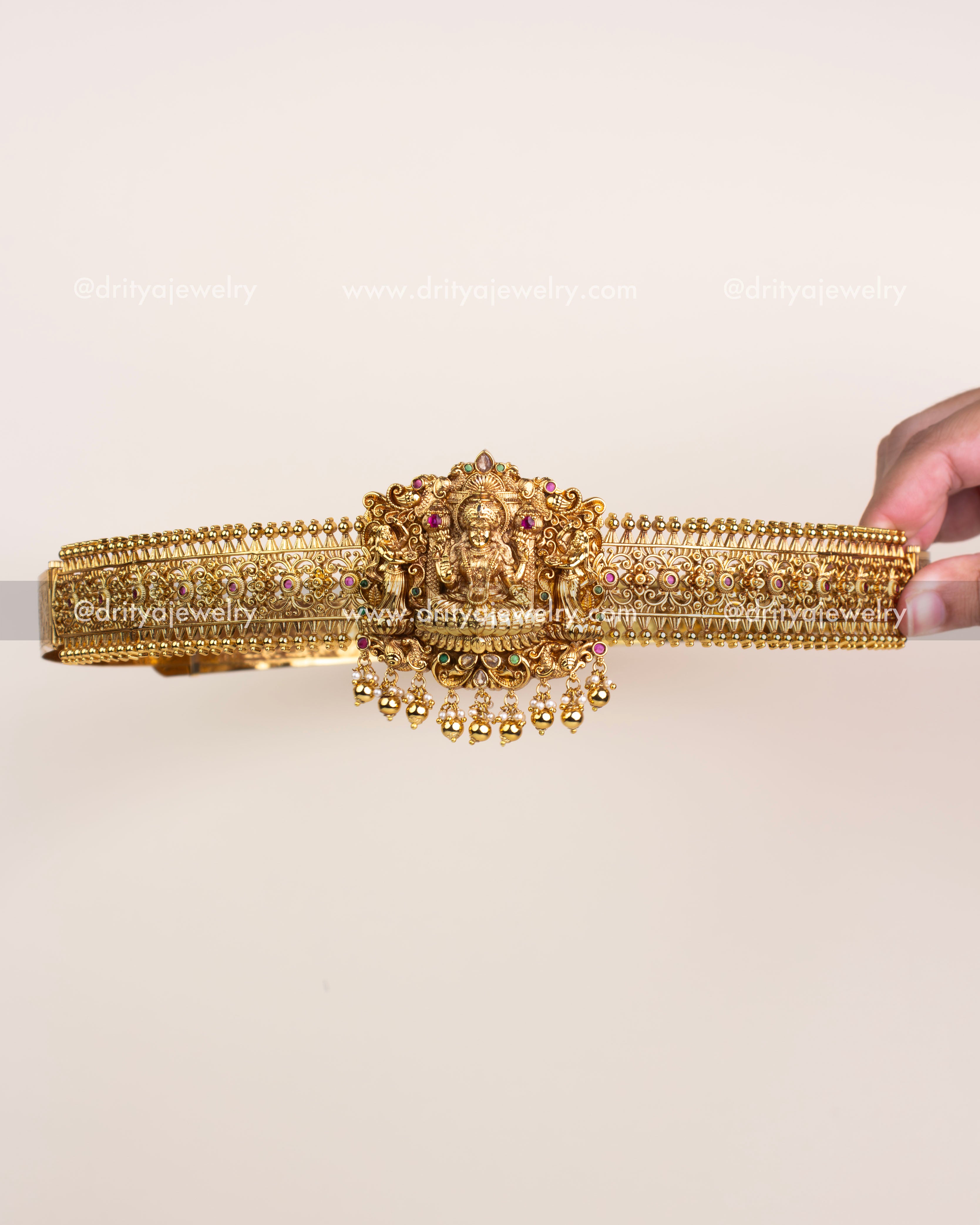 Antique gold temple vadanam with central Goddess Lakshmi motif and golden bead hangings.