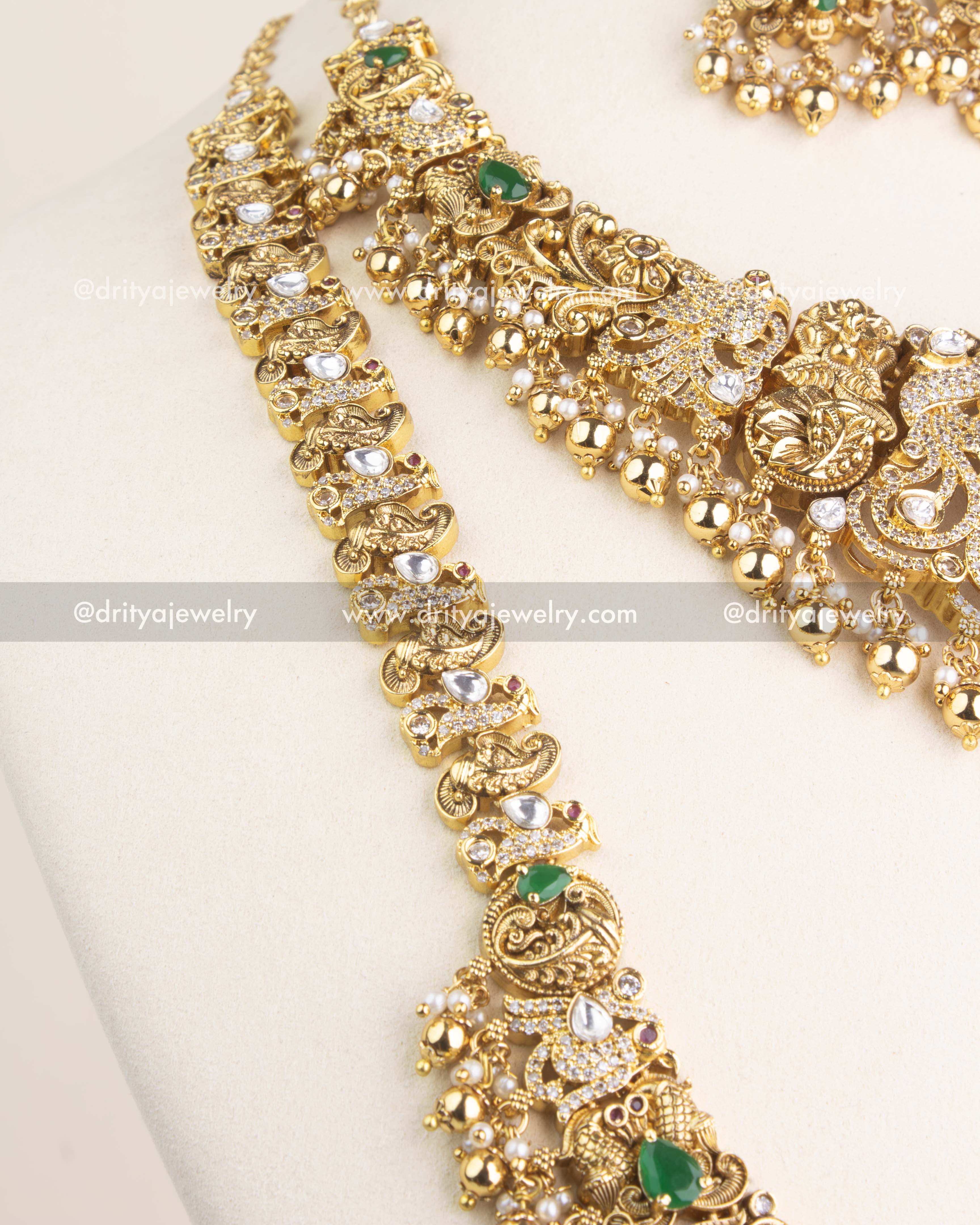 Detailed close-up of the antique necklace chain highlighting polki kundan stones, peacock motifs, and green stone accents.
