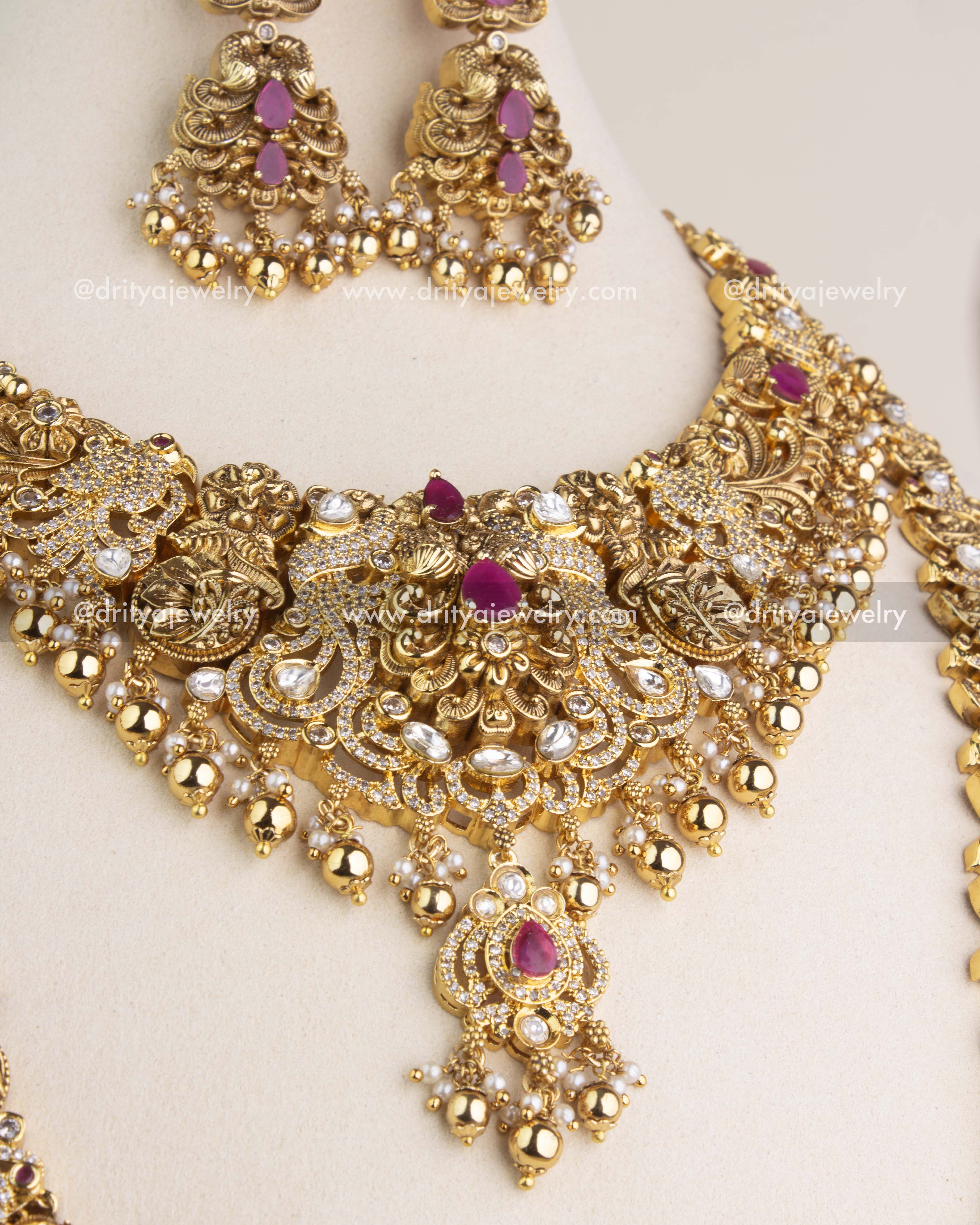 Close-up view of the antique short necklace featuring polki kundan work, ruby-red stones, and gold bead hangings.